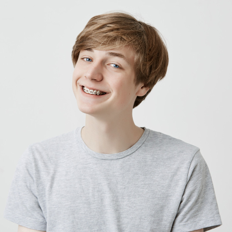 Young boy smiling and showing his braces
